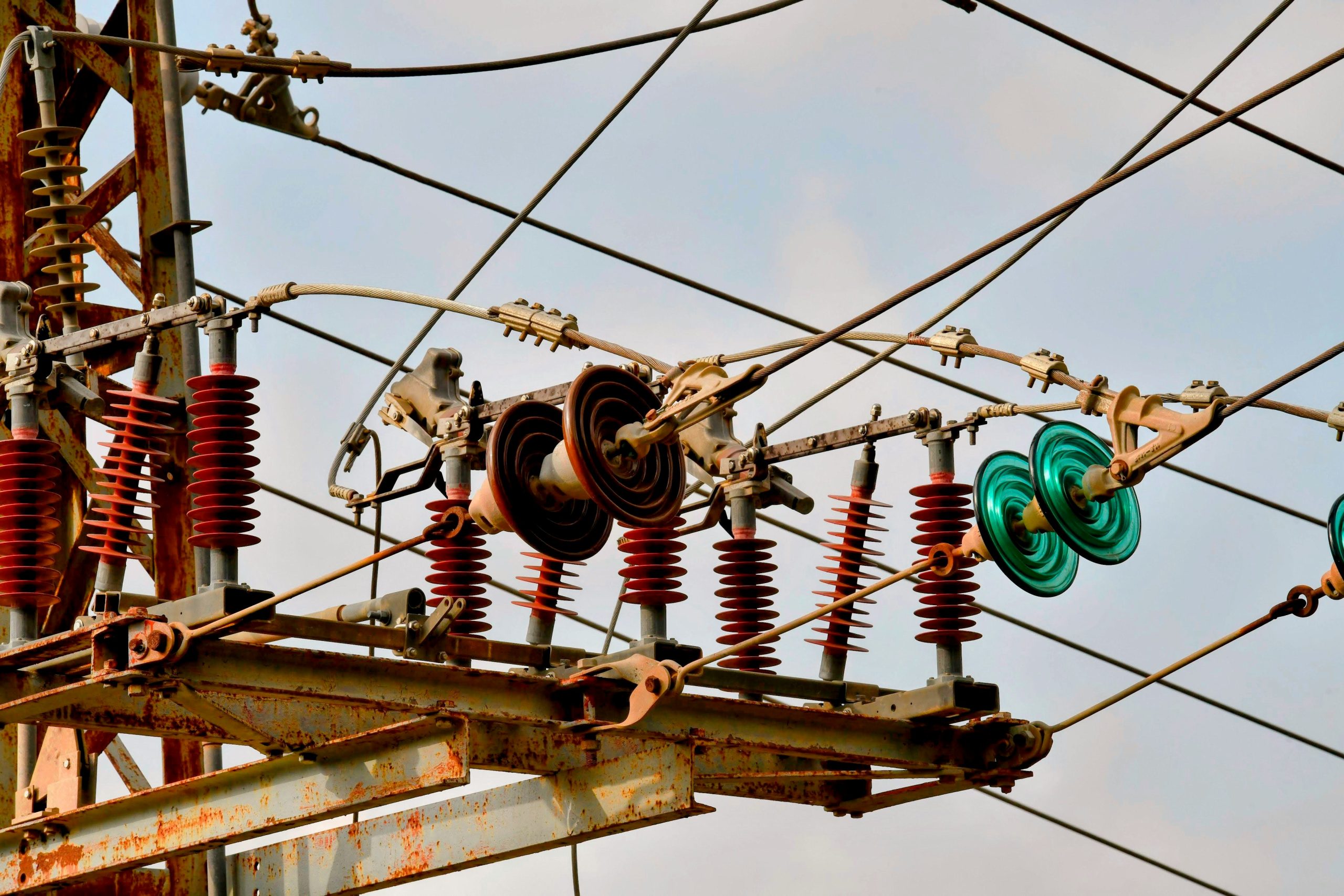 Hyper-realistic photography, a high voltage insulator assembly undergoing a mechanical load test, focus on the connection between the galvanized metal end fitting and the insulator body, industrial laboratory style, white background